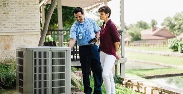 Homeowner and HVAC technician discussing an outdoor air conditioning system
